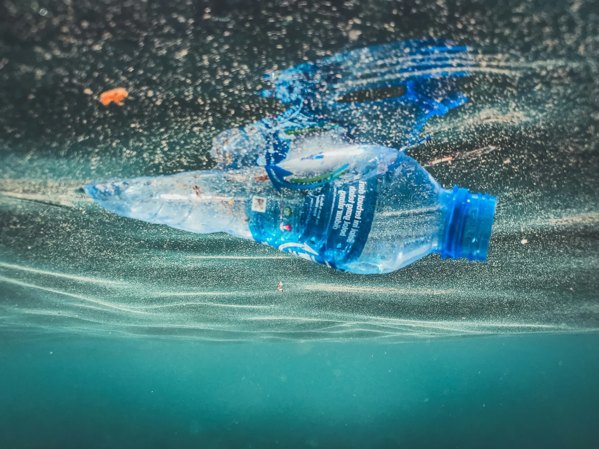 Discarded plastic bottles floating in polluted seawater