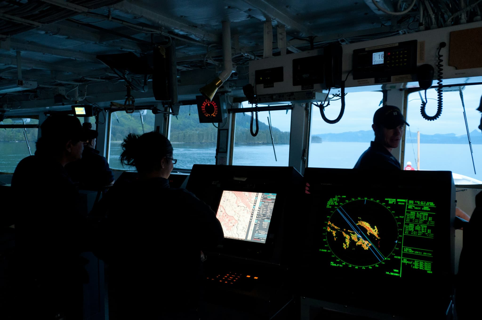 Marine survey team reviewing navigation and mapping displays aboard a vessel